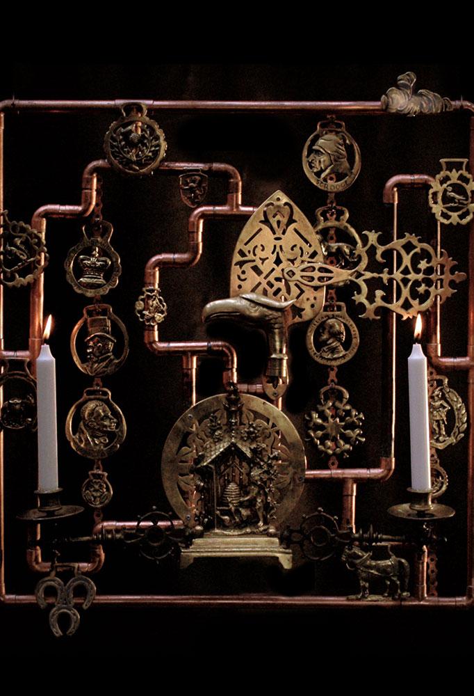 Made from a collection of mostly brass pieces mounted on a copper tube structure.